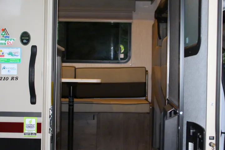 Interior of an RV rental, highlighting the comfortable dinette with bench seating and a window for your travel adventures.. Forest River Coachmen Leprechaun 2022