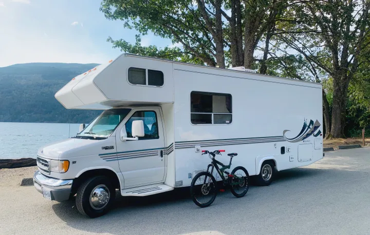 Scenic Ford E-450 RV rental by the water, mountains, and a bike, perfect for outdoor excursions and travel.. Slumber Queen Adventurer 2001