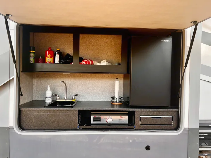 RV rental outdoor kitchen: sink, fridge, pull-out griddle, & storage. Ideal for camping trips!. Highland Ridge RV Open Range 2021