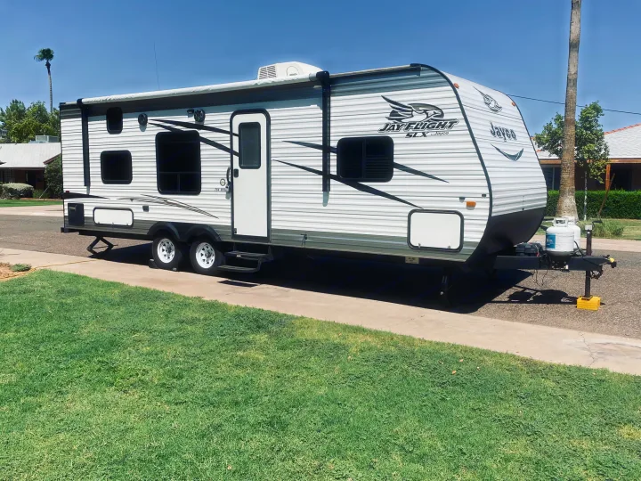 RV rental: White Jayco travel trailer parked on a sunny driveway with a grassy lawn.. Jayco Jay Flight SLX 2016