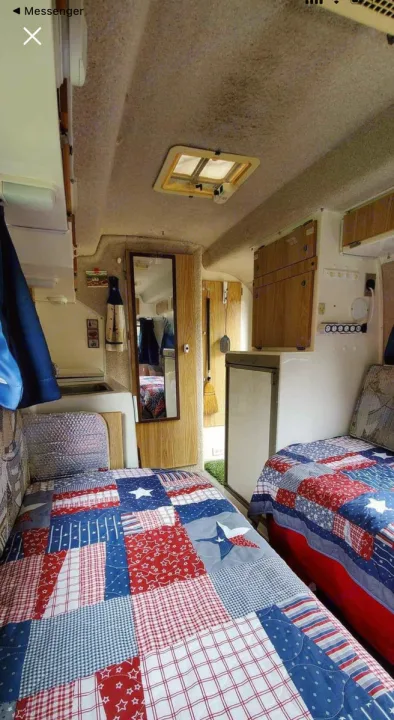 This cozy RV rental interior features patriotic twin beds, a compact kitchenette, and overhead storage. Ready for adventure!. Casita Casita Trailer 2007