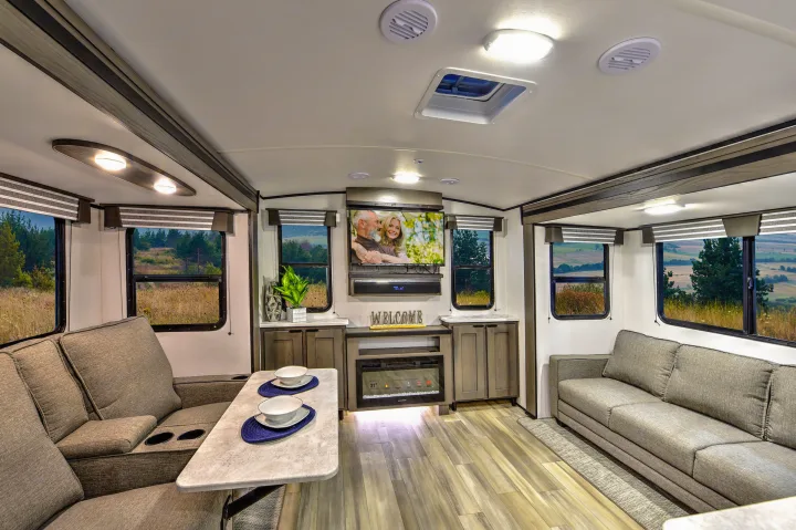Spacious RV rental living area with comfortable sofas, TV, fireplace, and scenic views, ideal for travel.. Cruiser RV MPG Ultra Lite 2022