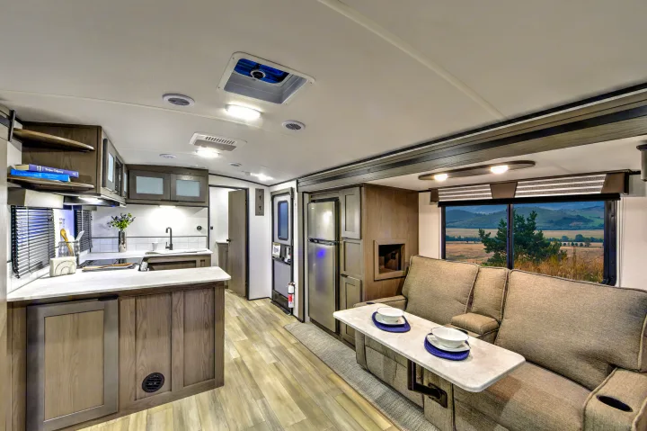 Spacious, modern RV rental interior with a full kitchen, comfy seating, and scenic window view.. Cruiser RV MPG Ultra Lite 2022