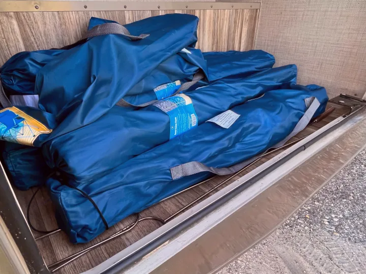 RV rental storage with neatly packed blue quad camp chairs, ready for your trip.. Thor Quantum 2017