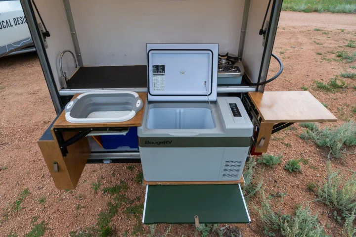 This RV rental's outdoor kitchen boasts a portable fridge, folding sink, stove, and convenient pull-out work surfaces.. White River X Camper Trail Explorer 2021