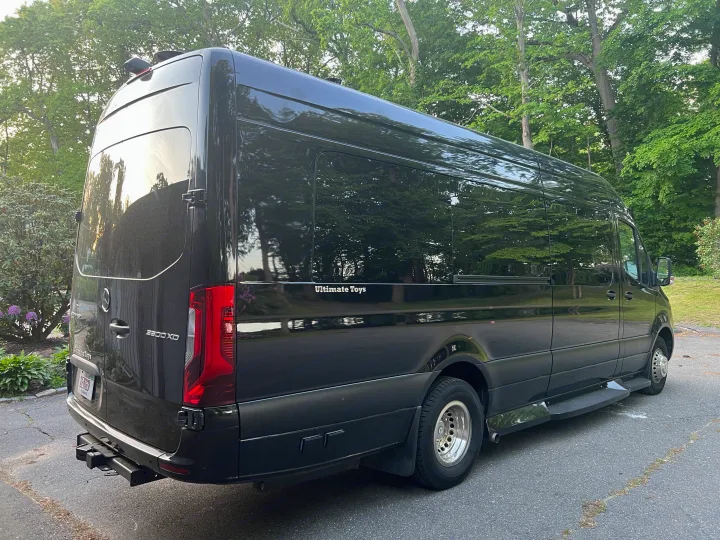Back view of a sleek black Mercedes-Benz Sprinter van, an "Ultimate Toys" luxury rv rental. Great for road trips!. Ultimate Toys Ultimate Coach 2022