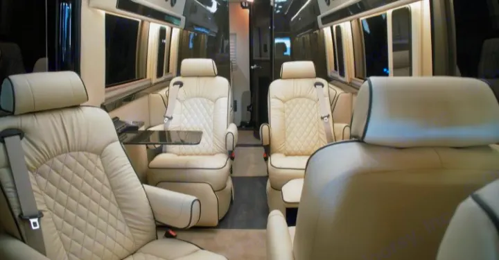 Step into luxury with this RV rental's interior, featuring plush cream quilted captain's chairs and a spacious cabin.. Ultimate Toys Ultimate Coach 2022