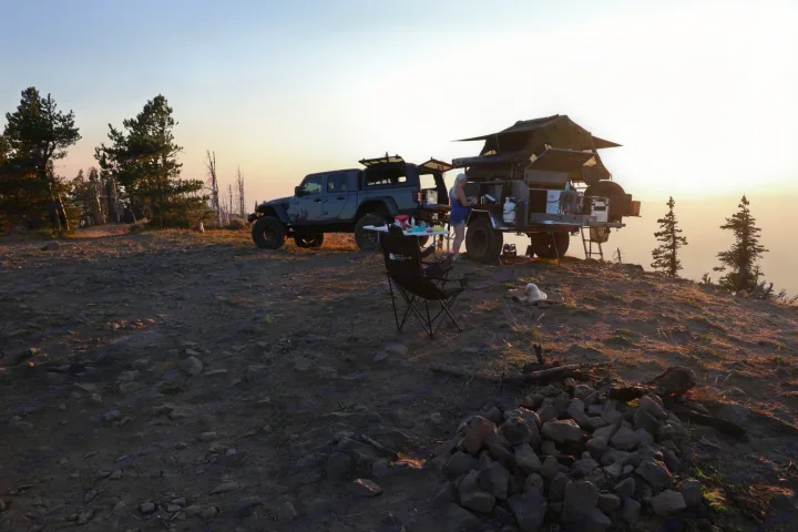 Scenic overlanding camp: Jeep & trailer with rooftop tent, person, dog, & fire pit at sunset. A rugged RV rental experience.. Vorsheer Vorsheer Trailer 2022