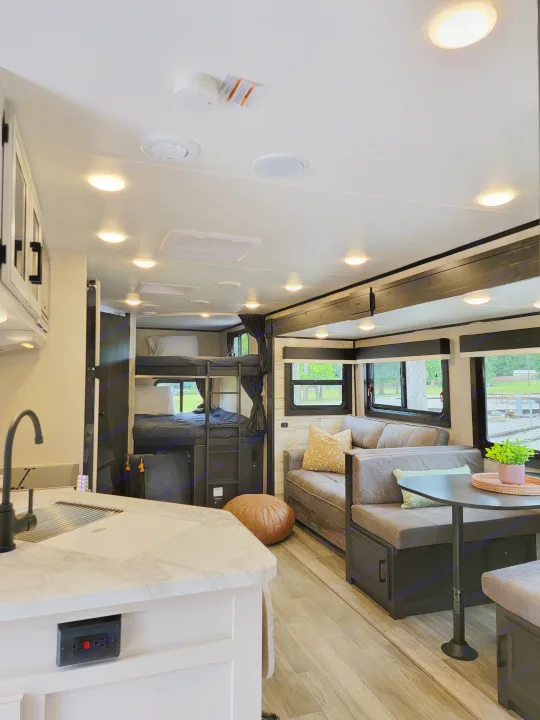 Spacious RV rental interior showing a kitchen, bunk beds, and a comfortable living area with a dinette setup.. Jayco Jay Feather 2023