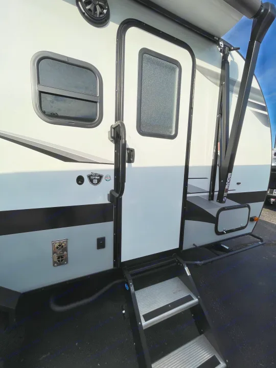 This white and gray RV rental features an exterior door with steps, windows, and an awning. Great for outdoor adventures.. Jayco Jay Feather 2022