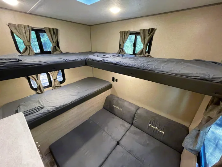 RV rental: Features L-shaped top bunks, a lower bed, and a Coachmen sofa, offering ample sleeping space.. Forest River Coachmen Catalina Legacy 2022