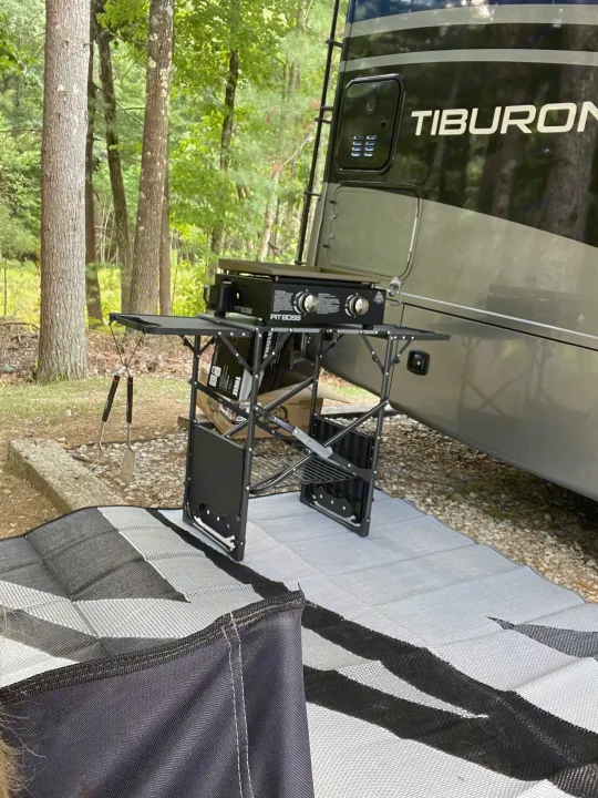 RV rental campsite setup: Tiburon RV, portable Pit Boss grill, and outdoor mat, perfect for a relaxing camp cookout.. Thor Tiburon 2020