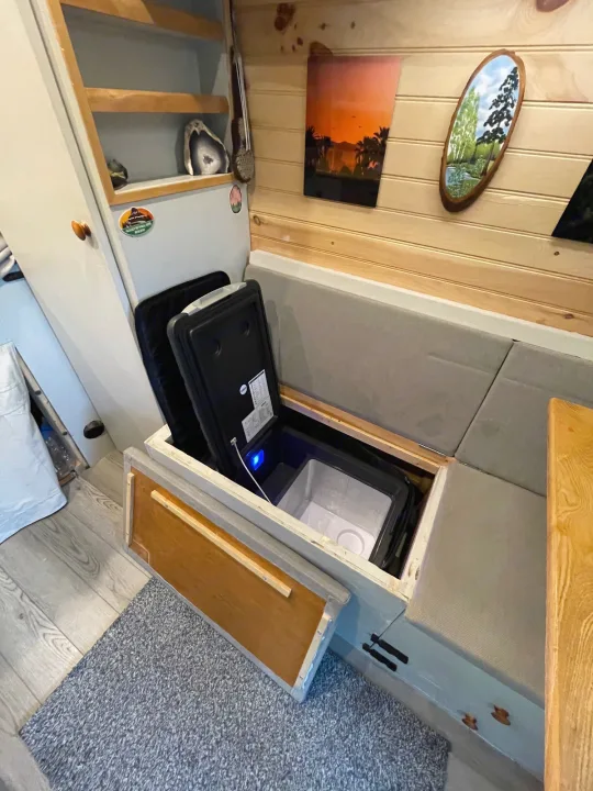 An RV rental's smart interior shows a portable refrigerator stored under the bench seat, offering efficient mobile living solutions.. Dodge Other 2018