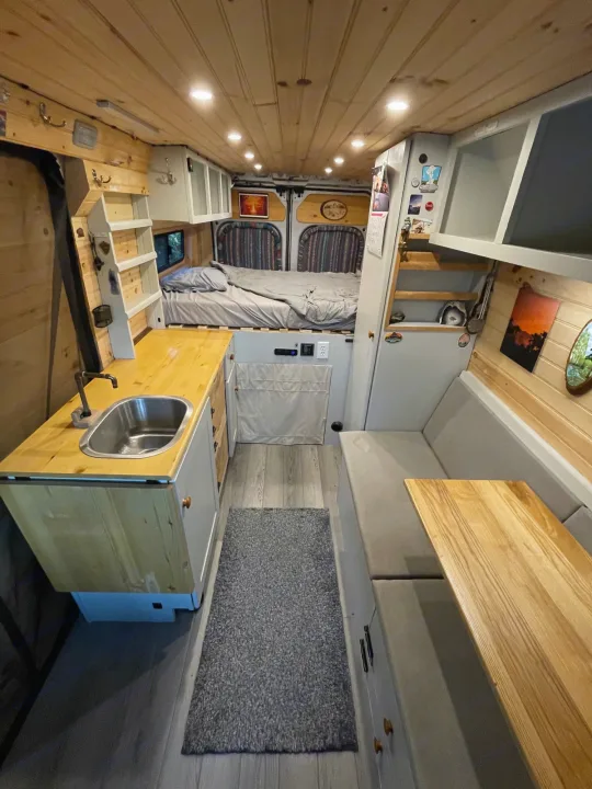 Step inside this cozy RV rental's custom van conversion, featuring a kitchen, bed, and lounge area.. Dodge Other 2018