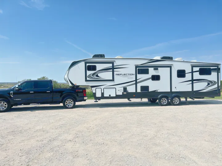 A black pickup truck tows a Grand Design Reflection fifth-wheel RV. Experience travel & camping by considering an RV rental.. Grand Design Reflection 2021