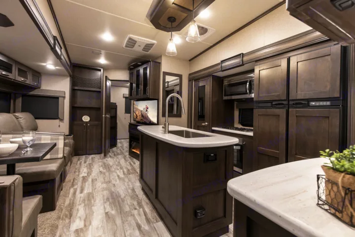 This RV rental features a spacious, modern interior with a well-equipped kitchen island, dining, and living areas.. Grand Design Reflection 2021