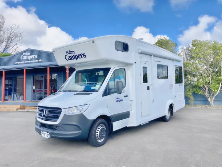 White Mercedes-Benz motorhome from Palmy Campers, an RV rental service, parked outside their hire office on a sunny day.. Mercedes-Benz Sprinter 2022