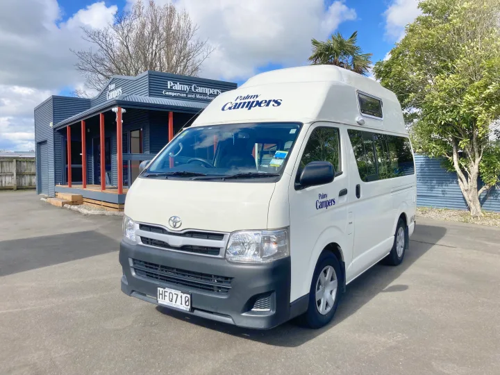 White Palmy Campers RV rental parked outside their building, a campervan or motorhome for hire.. Toyota Hiace 2013
