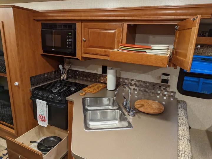 Enjoy a fully equipped kitchen on your next RV rental adventure, featuring a stove, microwave, and sink.. Winnebago Vista 2018