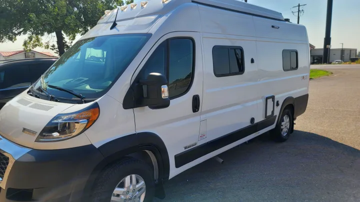 Side view of a white Winnebago camper van, ideal for an RV rental or a fun road trip.. Winnebago Solis 2023