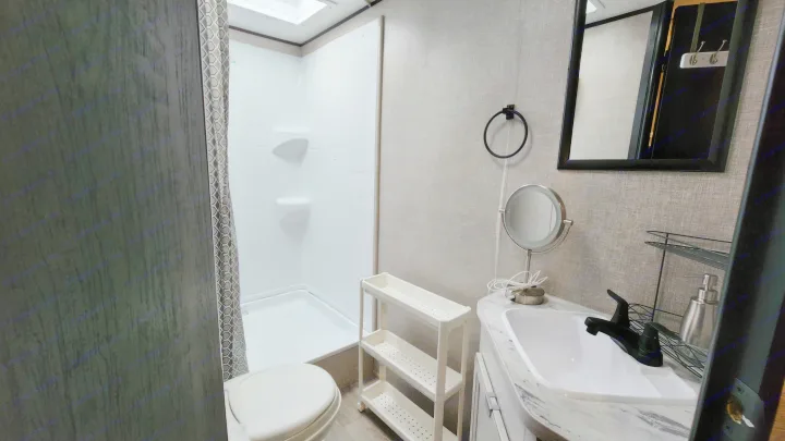 This compact RV rental bathroom features a shower, toilet, and sink with a modern, clean design, perfect for travelers.. Jayco Jay Flight SLX 2022