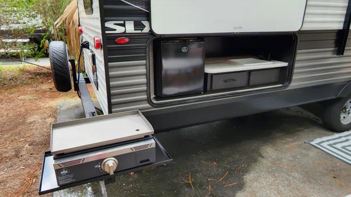 This RV rental features a convenient outdoor kitchen with a mini-fridge, sink, storage, and a griddle ready for cooking.. Jayco Jay Flight SLX 2022
