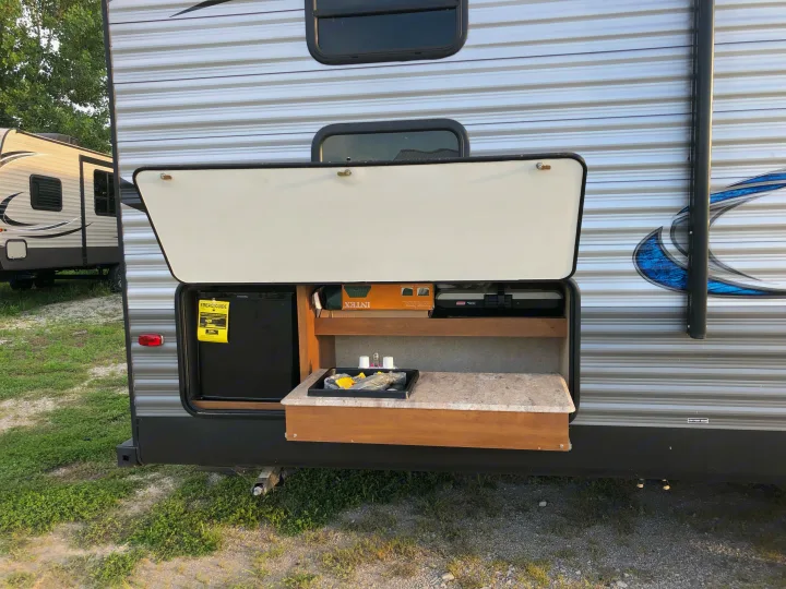 This RV rental features an outdoor kitchen with a fridge, sink, and grill, perfect for camping trips.. Coachmen 5ZT2CAUB5JU029455 2018
