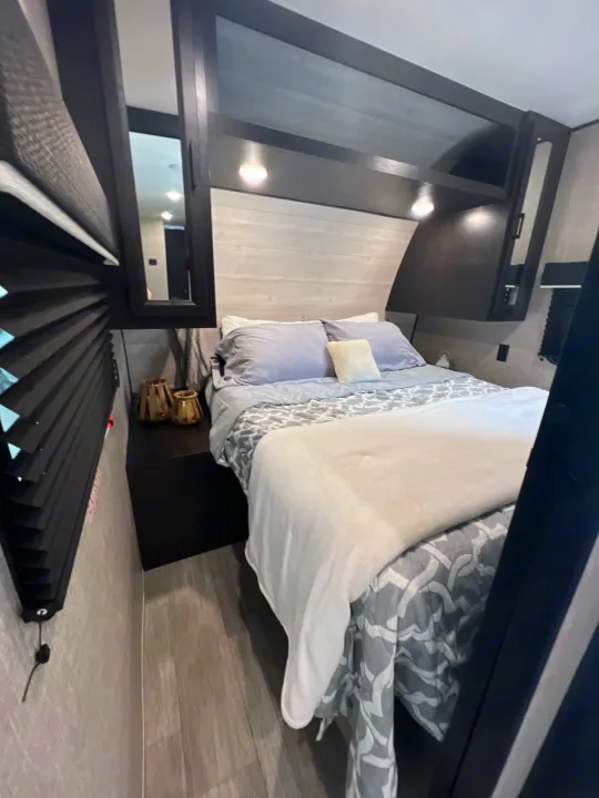 Cozy RV rental bedroom with modern decor, a comfy bed, and convenient overhead storage. Ideal for travel.. Jayco Jay Flight 267BH 2023