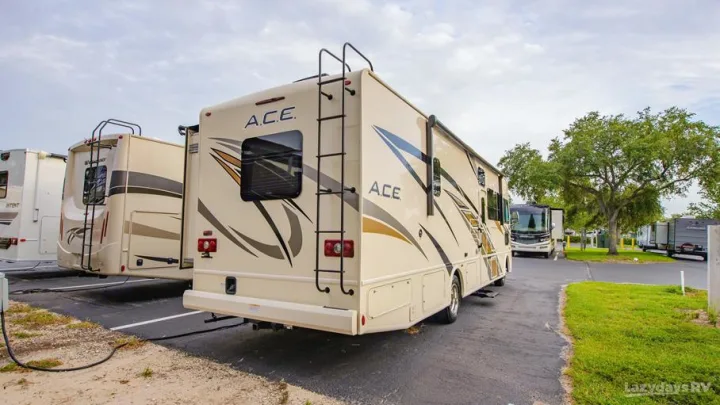 Explore diverse rv rental options! This Class A motorhome and others are parked at an RV sales or rental lot, showcasing various models.. Thor A.C.E. 2020