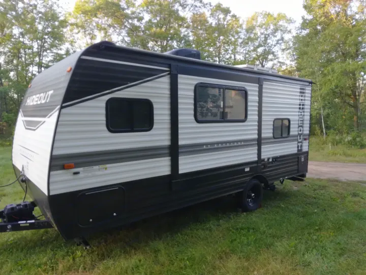 Spacious Hideout travel trailer, perfect for your next rv rental adventure. Parked on grass with trees in the background.. Keystone RV Hideout 2022