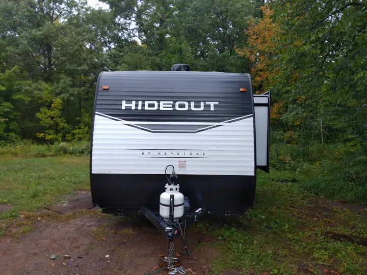 RV rental: Front view of a black and white Hideout travel trailer, by Keystone, parked in a wooded campsite.. Keystone RV Hideout 2022