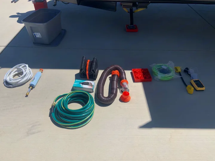 Essential RV rental setup gear: freshwater, sewer, and garden hoses, filter, leveling blocks, and electrical connectors.. Dutchmen Coleman Lantern 2021