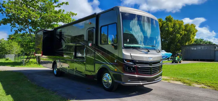 Spacious, sleek motorhome RV rental parked on a driveway, ready for your road trip adventure under a blue sky.. Bounder Bounder Motorhome 2021