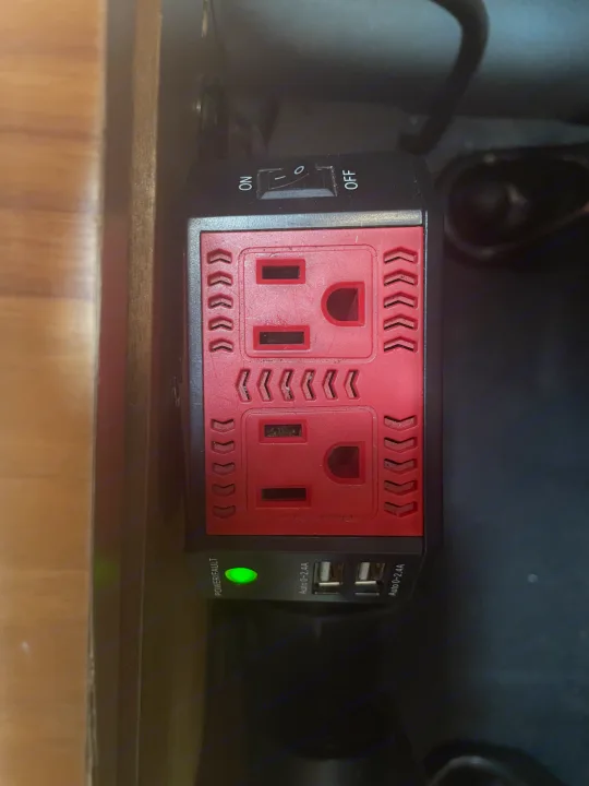 RV rental: Power inverter with red AC outlets, USB ports, and green power light, ready for charging devices while traveling.. Nissan Elgrand 2021