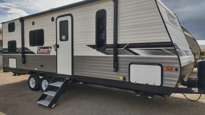 Coleman travel trailer ideal for rv rental adventures. This side view shows its new exterior, entry steps, and wheels.. Dutchmen Coleman Lantern LT 2022