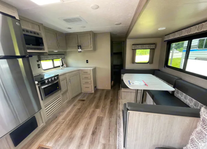 Modern RV rental interior: full kitchen (fridge, stove, sink) & spacious dinette for comfortable living.. Forest River Coachmen Catalina Legacy 2022