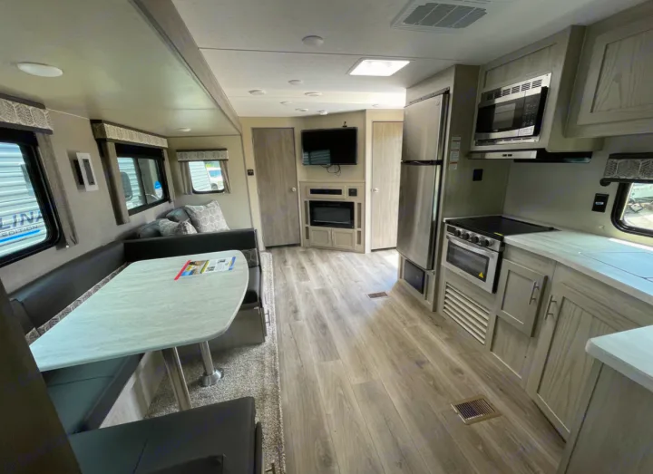 Spacious RV rental interior featuring a modern kitchen, dining booth, and living area for comfortable travel.. Forest River Coachmen Catalina Legacy 2022