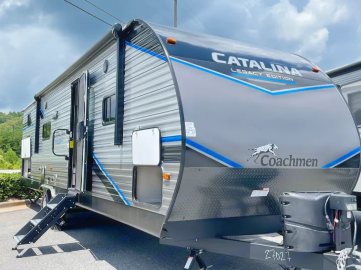 Gray & blue Coachmen Catalina Legacy Edition travel trailer with awning extended and steps down, perfect for an RV rental.. Forest River Coachmen Catalina Legacy 2022