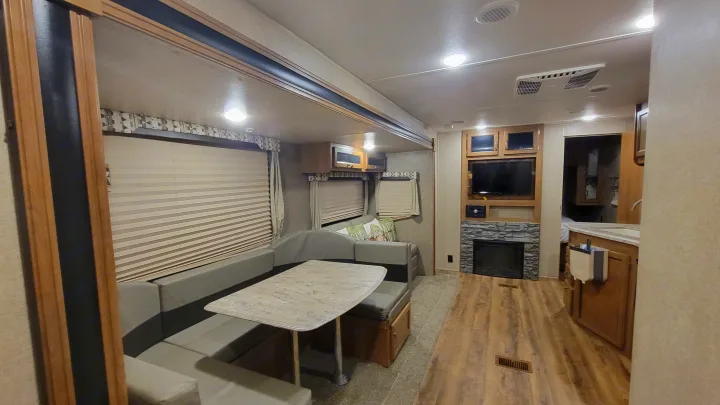 Explore this inviting RV rental: A comfortable dinette, functional kitchen, and living area with TV/fireplace.. Coachmen 323BHDSCK 2019