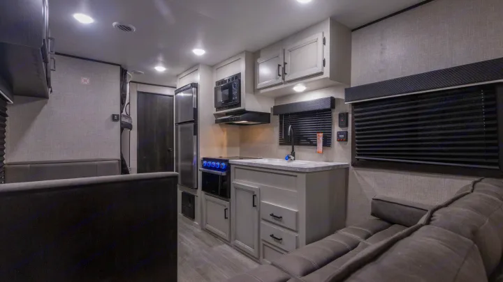 This clean, modern RV rental interior features a compact kitchen with full appliances & comfortable living space.. Jayco Jay Flight SLX 2022