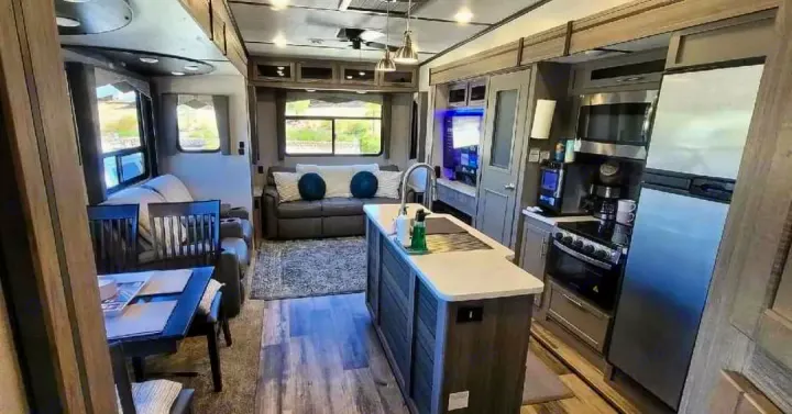Spacious and modern RV rental interior featuring a full kitchen, living area, and dining space, perfect for travel.. Crossroads RV Volante HP 2022
