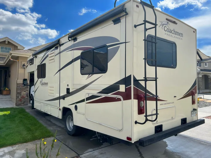 Spacious Coachmen Freelander RV rental parked on a sunny day driveway next to a home, ready for adventures.. Forest River Coachmen Freelander 2019