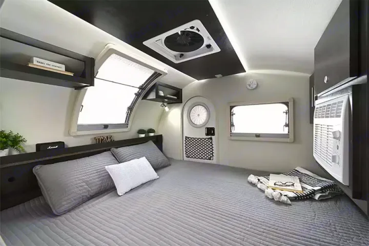 Step inside this cozy RV rental: a modern, compact bedroom with a queen bed, bright windows, AC, and storage.. nuCamp T@G XL Boondock 2022