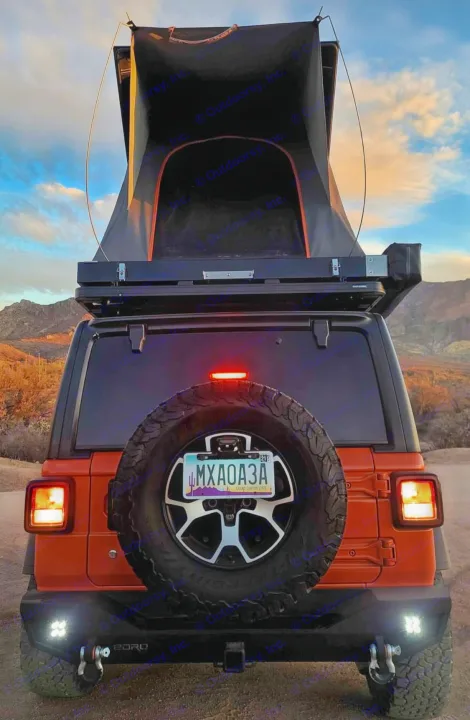 Rear view of an orange Jeep with a rooftop tent set up in a desert at sunset. Perfect RV rental for an overland adventure!. Jeep Wrangler 2018