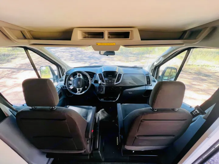 Inside an rv rental: View from rear of cabin showing driver's cockpit, seats, and road ahead.. Coachmen Beyond 22D 2020