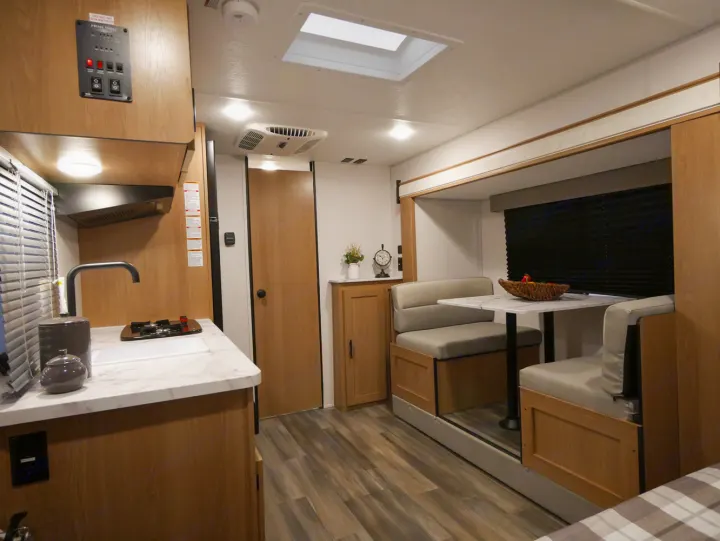 Inside this RV rental, find a bright, well-equipped kitchen and a cozy dinette area, offering comfort on the road.. Forest River Avenger 2022