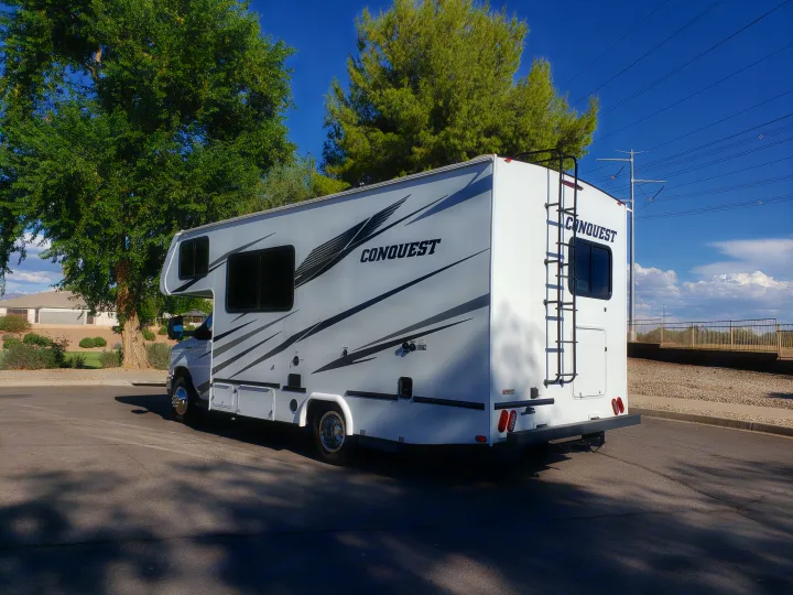 A pristine white Conquest RV rental awaits your next adventure, parked in a sunny outdoor setting.. Gulf Stream Conquest 2022