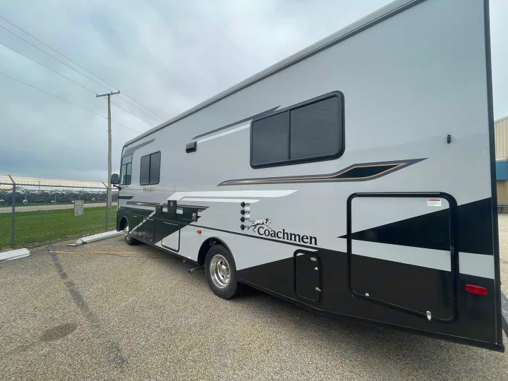Sleek gray & black Coachmen Pursuit motorhome rv rental parked outdoors, ready for adventure.. Coachmen Pursuit 2023