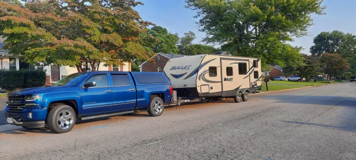 This blue pickup truck tows a sleek "BULLET Ultra Lite" travel trailer, ideal for an exciting rv rental getaway.. Keystone RV Bullet Ultra Lite 2016