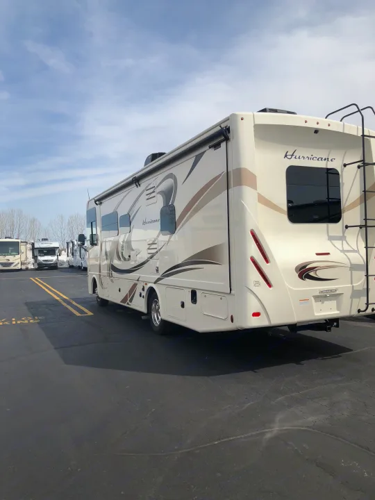 Cream-colored Hurricane Class A RV motorhome at an RV rental lot, seen from the rear, ready for your journey.. Thor Hurricane 2018